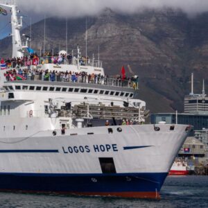 A picture of a large ship called the Logos Hope showing many people on board with flags from lots of different countries